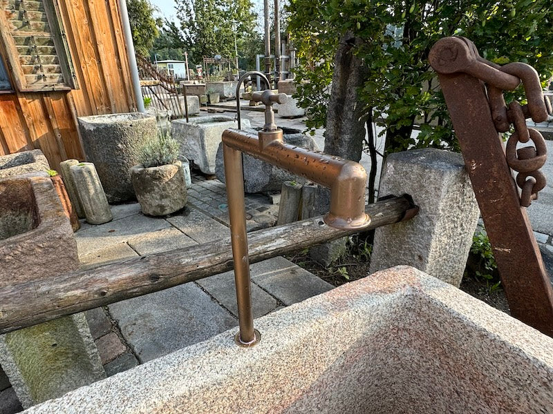 Steinbrunnen mit Naturoberfläche und Wasserauslauf