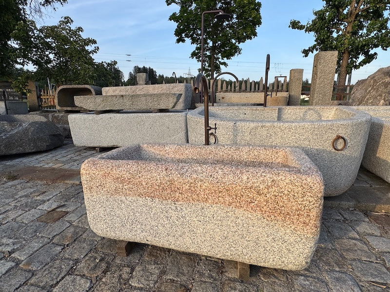 Steinbrunnen aus grauem Granit und Messingeinlauf