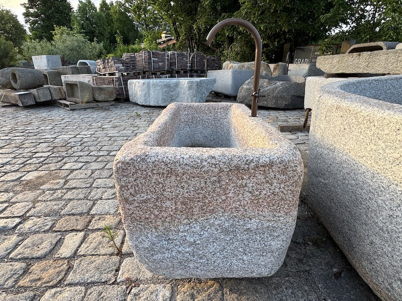 Steinbrunnen aus grauem Granit Seitenansicht