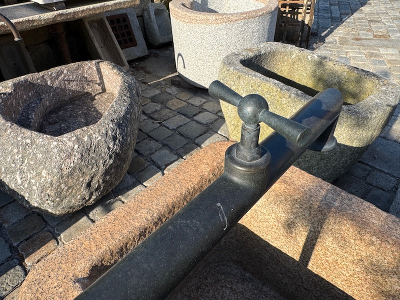Steinbrunnen Österreich mit Wasserhahn und Handrad