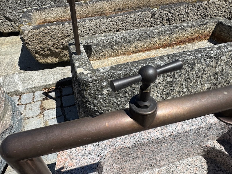 Findlingsbrunnen mit dunklen und rosa Einschlüssen