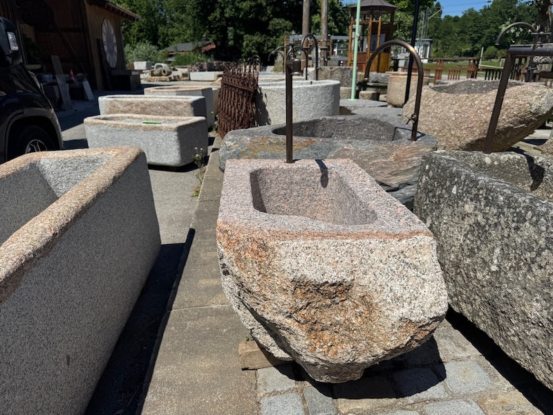 Findlingsbrunnen mit dunklen und rosa Einschlüssen