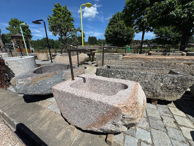 Findlingsbrunnen mit dunklen und rosa Einschlüssen