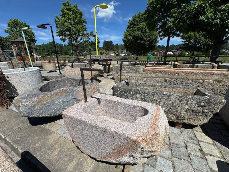 Findlingsbrunnen mit dunklen und rosa Einschlüssen