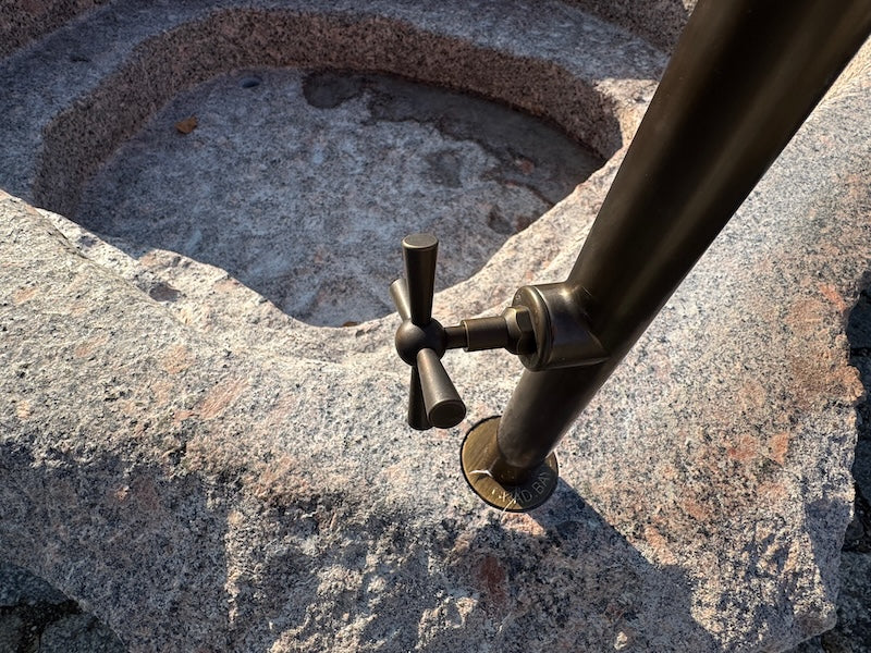 Findlingsbrunnen mit dunklen und rosa Einschlüssen