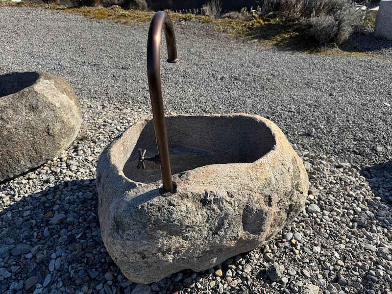 Findlingsbrunnen mit rostfarbenen Stellen