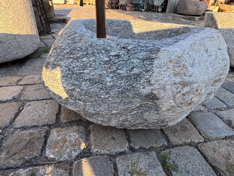 Findlingsbrunnen mit rostfarbenen Stellen