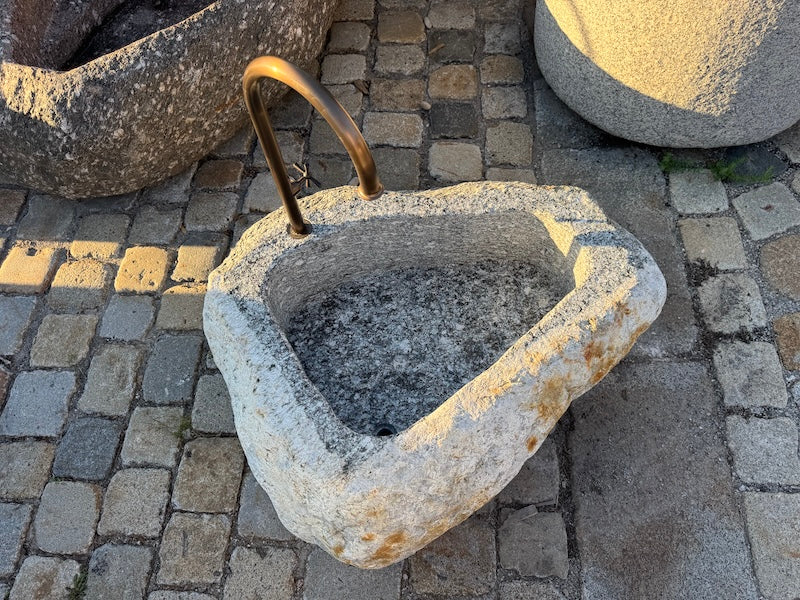 Findlingsbrunnen mit rostfarbenen Stellen aus Bayern