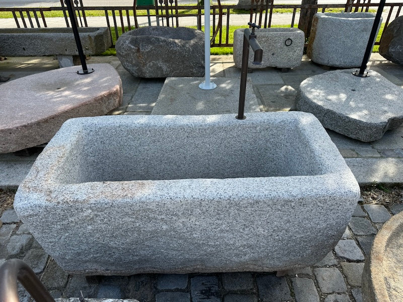 Steinbrunnen aus grauem Granit Seitenansicht