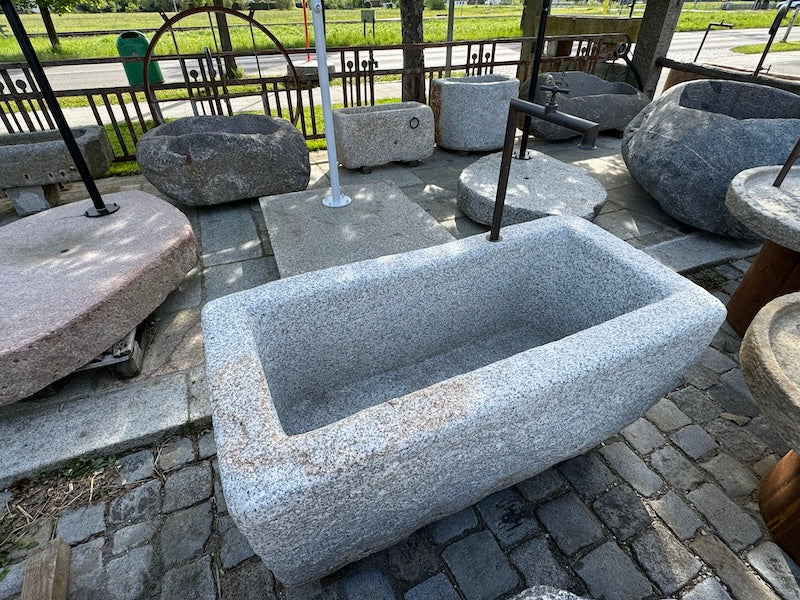 Steinbrunnen aus grauem Granit und Messingeinlauf