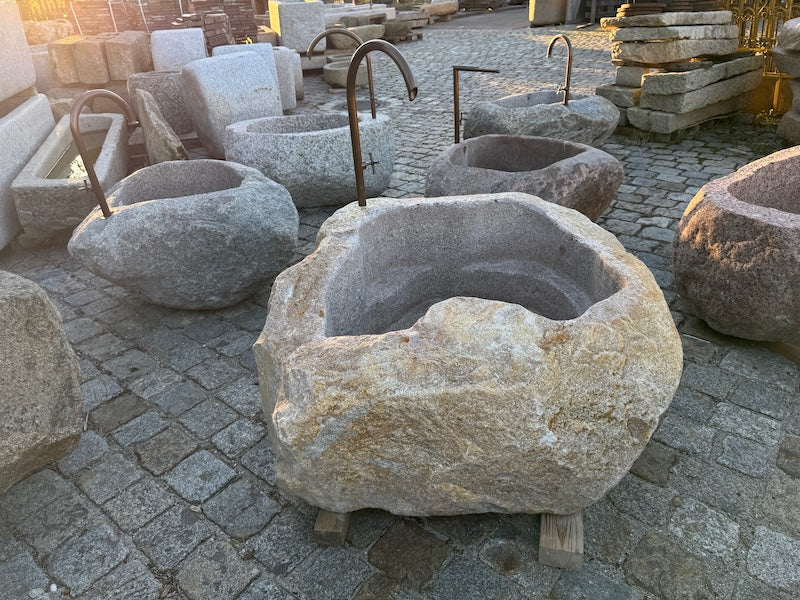 Findlingsbrunnen mit rostfarbenen Stellen aus Bayern