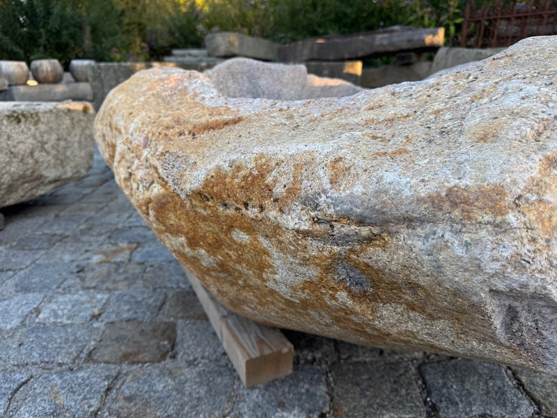 Findlingsbrunnen mit rostfarbenen Stellen