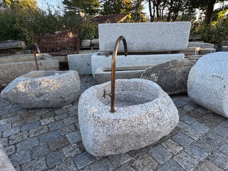 findlingsbrunnen mit wasserhahn