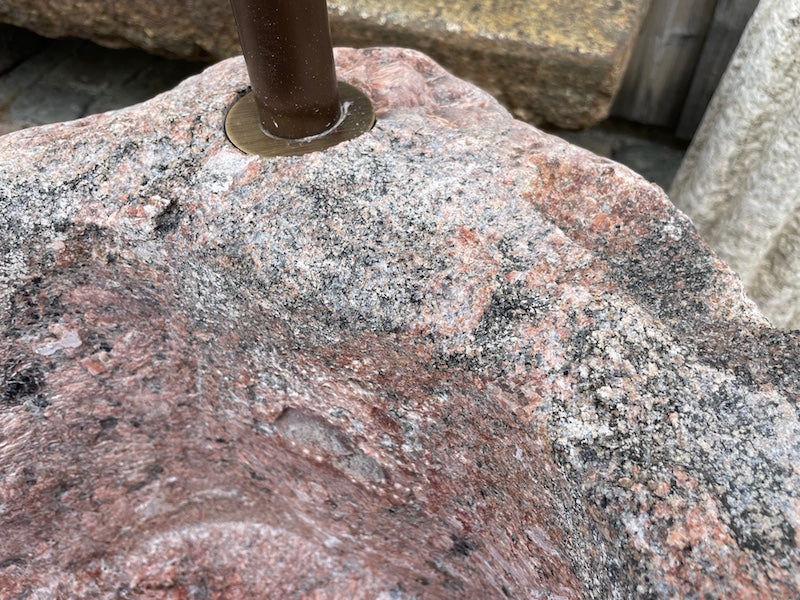 Findlingsbrunnen mit roter Oberfläche