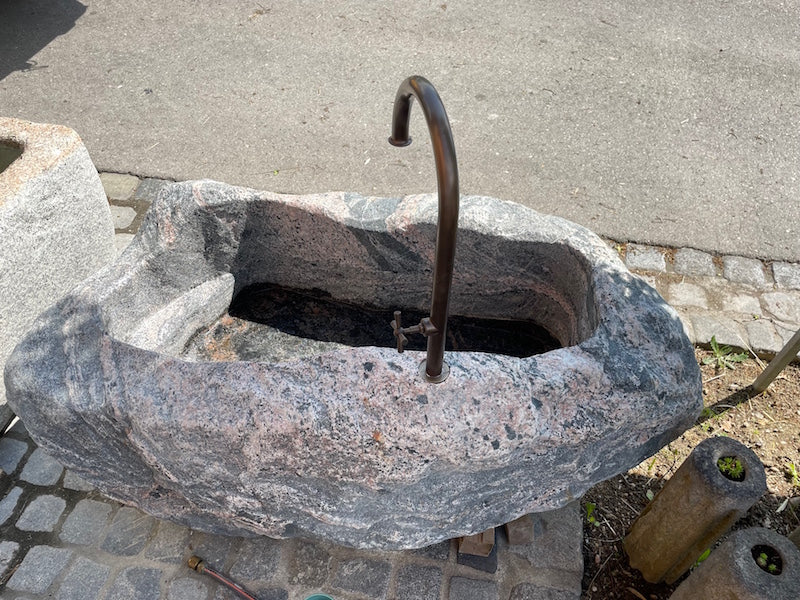 Alter Findlingsbrunnen mit wunderschöner Farbe Seitenansicht