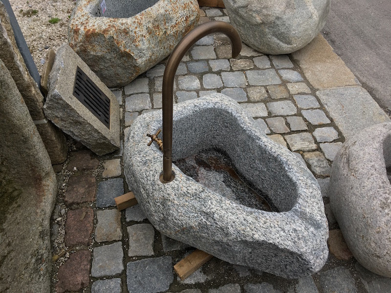 Kleiner Findlingsbrunnen mit farblichen Einschlüssen Struktur