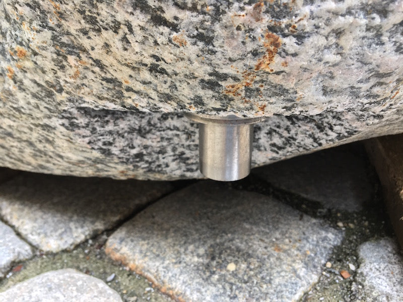 Kleiner Findlingsbrunnen mit farblichen Einschlüssen.