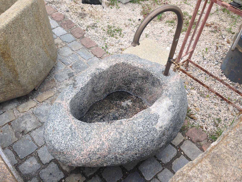 Findlingsbrunnen mit roten Adern mit Wassereinlauf