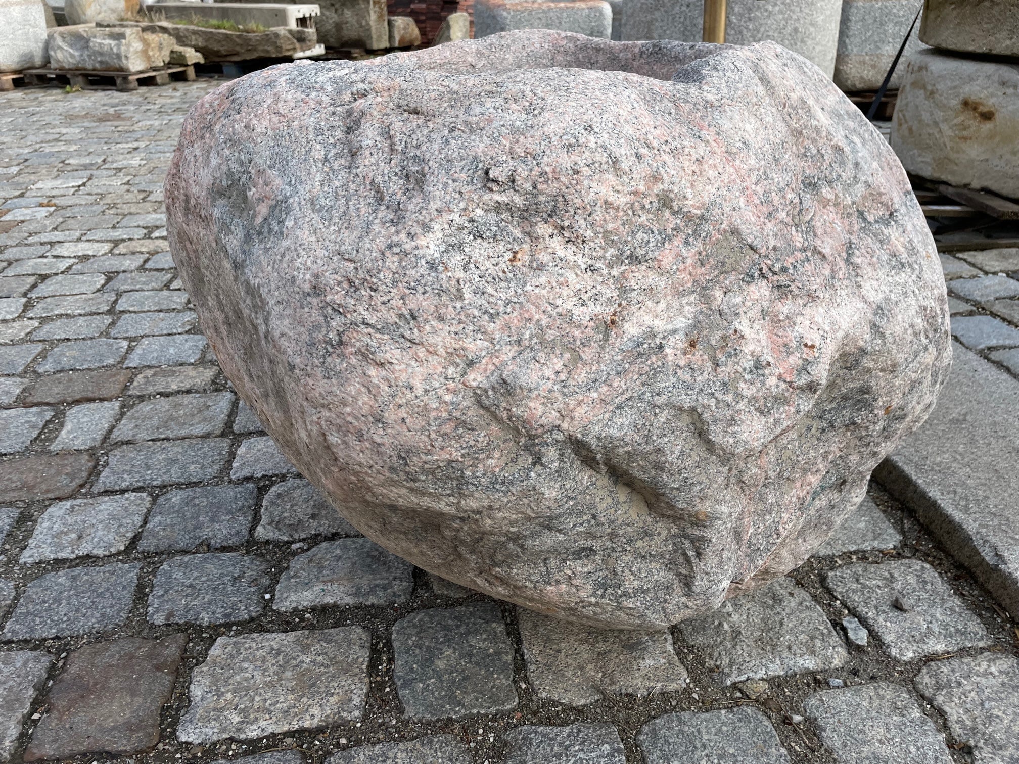 Findlingsbrunnnen rosa mit schwarzen Einschlüssen