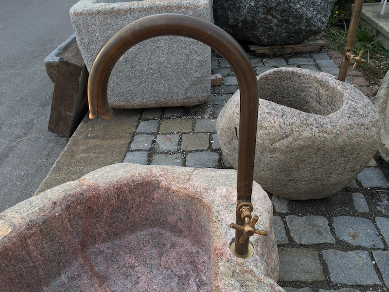 Findlingsbrunnen in rosa mit schwarzen Schlieren