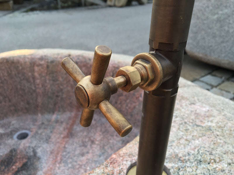 Findlingsbrunnen in rosa mit Wassereinlauf und Handrad