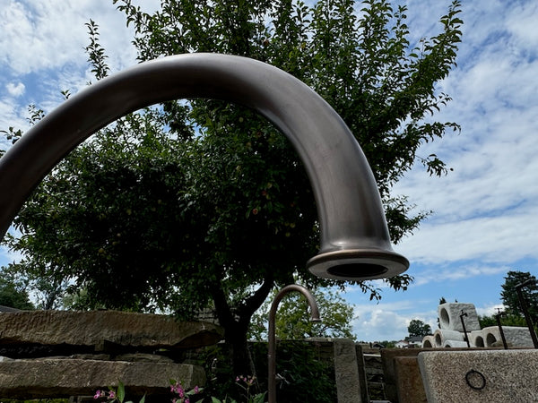 Nordischer Findlingsbrunnen mit offenen Wassereinlauf