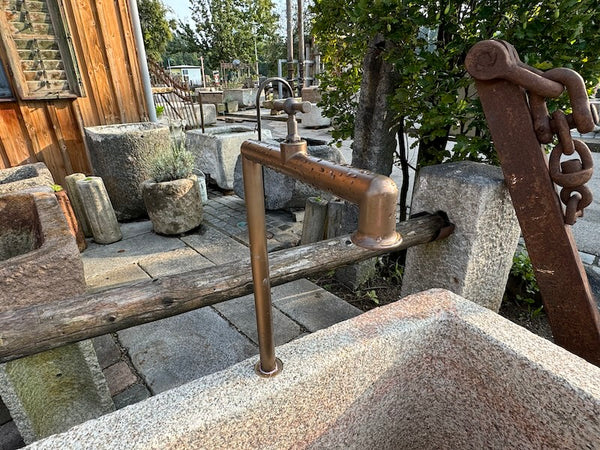 Steinbrunnen mit Naturoberfläche und Wasserauslauf