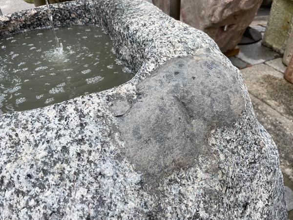 Findlingsbrunnen aus grauem Granit