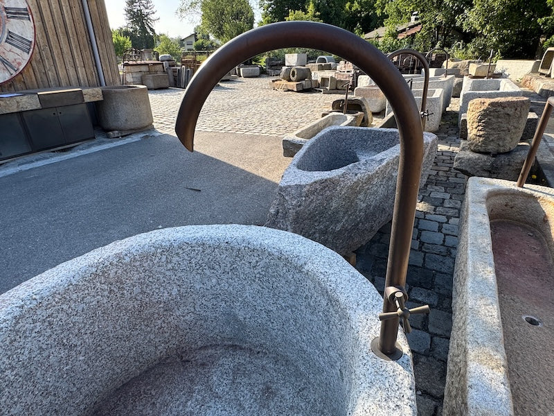 Granitbrunnen rund Wasserauslauf