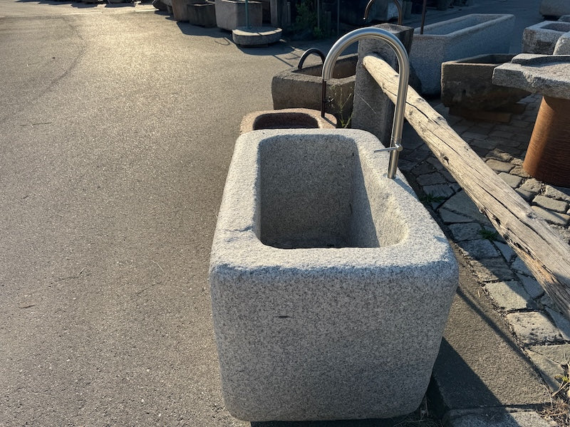 Steinbrunnen outdoor mit Wasserauslauf