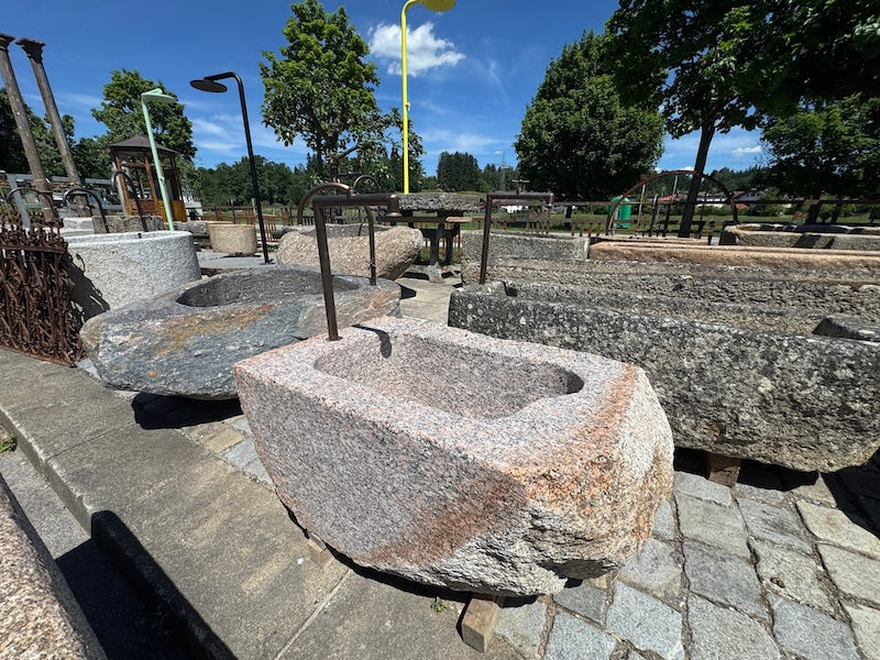 Findlingsbrunnen mit dunklen und rosa Einschlüssen