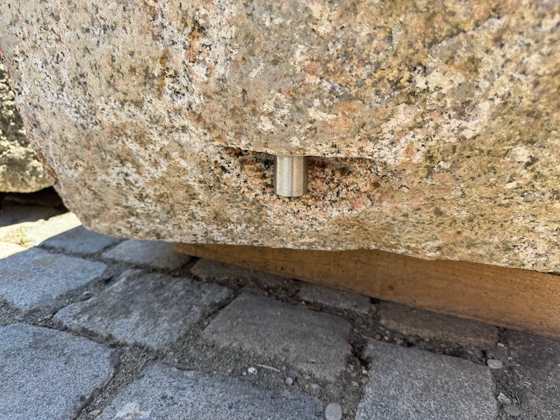 Findlingsbrunnen mit dunklen und rosa Einschlüssen