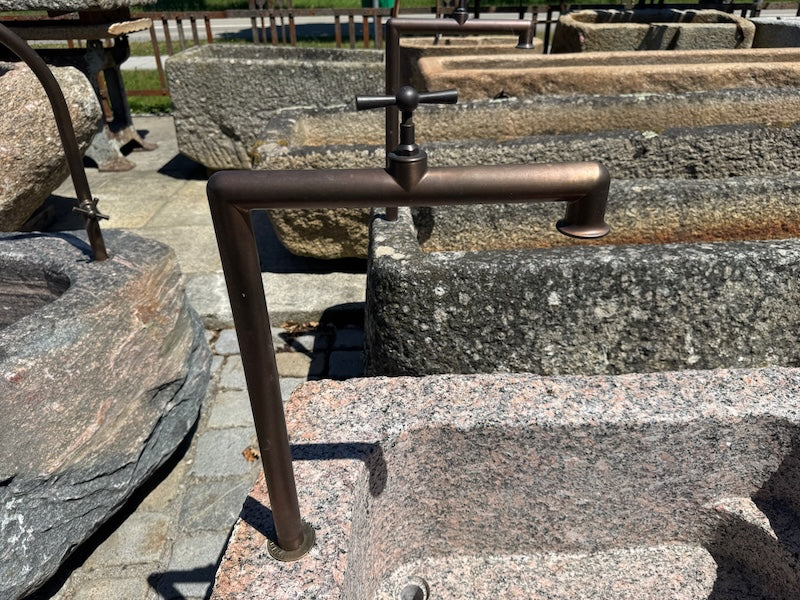 Findlingsbrunnen mit dunklen und rosa Einschlüssen