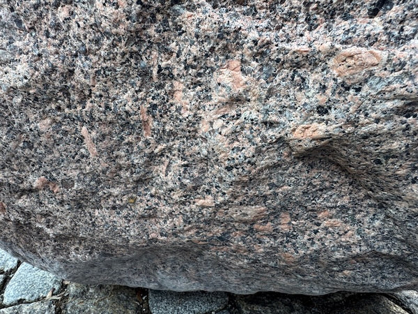 Findlingsbrunnen mit dunklen und rosa Einschlüssen