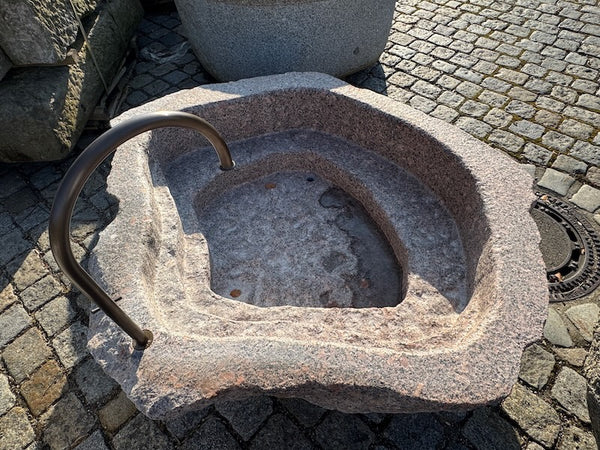 Findlingsbrunnen mit rosa Einschlüssen