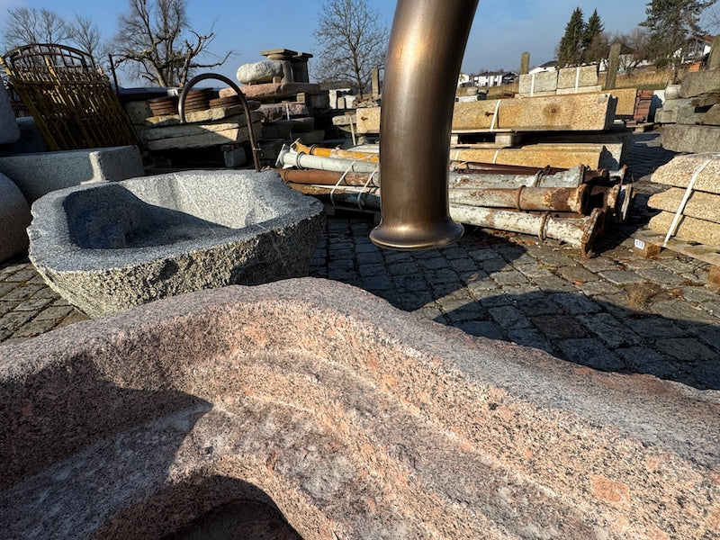 Findlingsbrunnen mit dunklen und rosa Einschlüssen