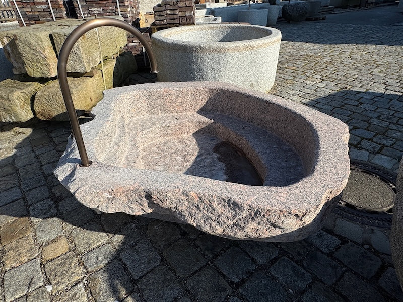 Findlingsbrunnen mit rosa Einschlüssen