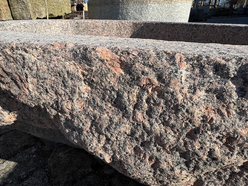 Findlingsbrunnen mit dunklen und rosa Einschlüssen Detail Oberfläche