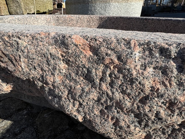 Findlingsbrunnen mit dunklen und rosa Einschlüssen Detail Oberfläche