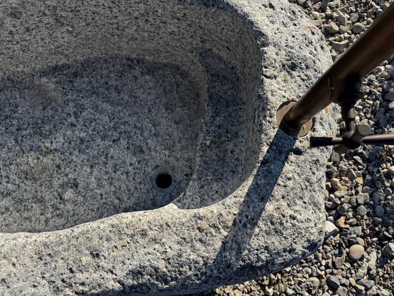 Findlingsbrunnen mit eckigen Einlauf aus rotem Granit