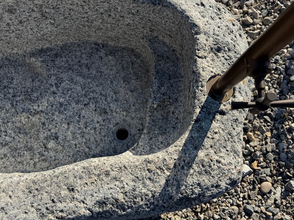 Findlingsbrunnen mit eckigen Einlauf aus rotem Granit