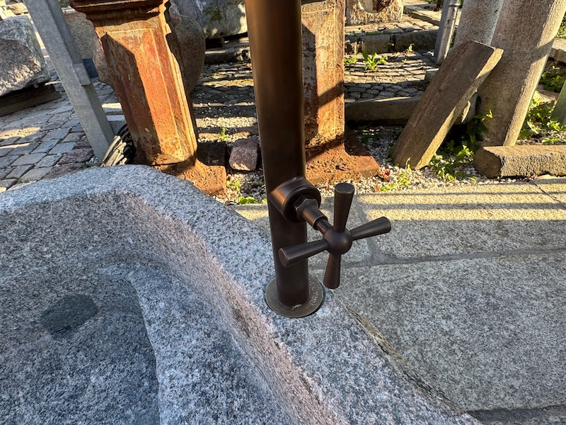 Findlingsbrunnen Schweiz Wassereinlauf mit Handrad