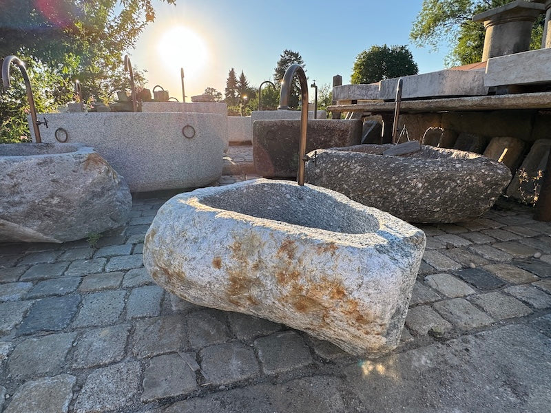 Findlingsbrunnen mit rostfarbenen Stellen