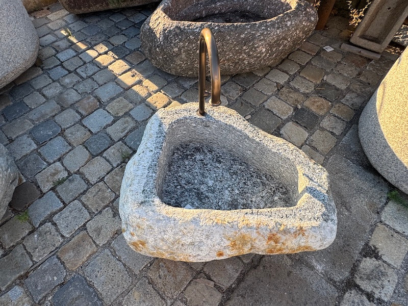 Findlingsbrunnen mit rostfarbenen Stellen