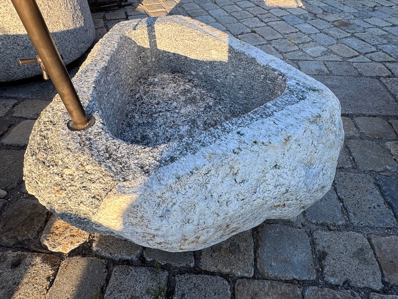 Findlingsbrunnen mit rostfarbenen Stellen