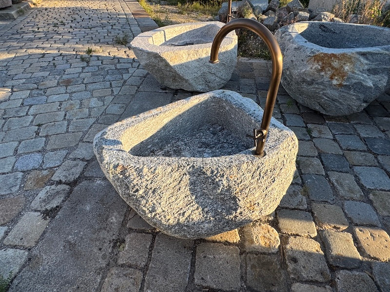 Findlingsbrunnen mit rostfarbenen Stellen