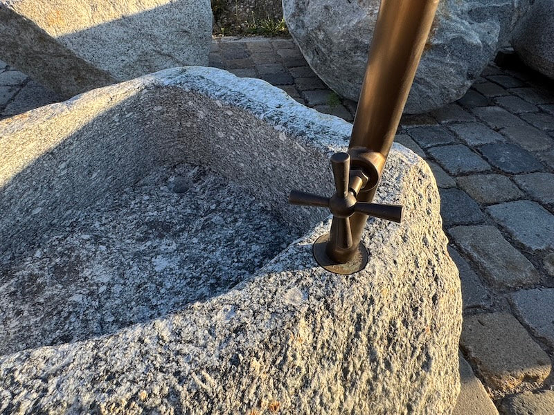 Findlingsbrunnen mit rostfarbenen Stellen