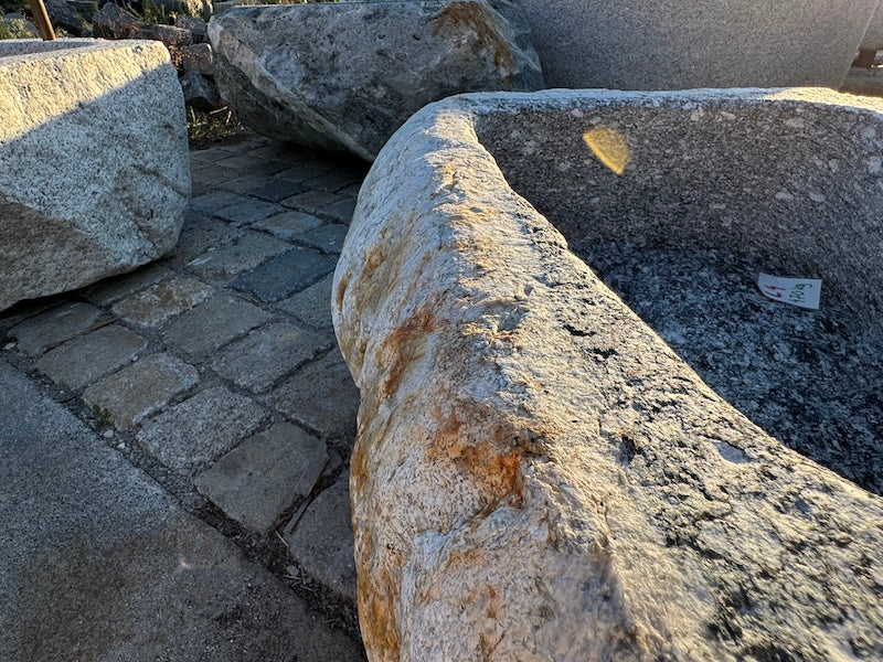 Findlingsbrunnen mit rostfarbenen Stellen