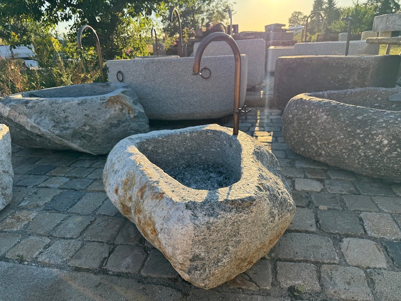 Findlingsbrunnen mit rostfarbenen Stellen