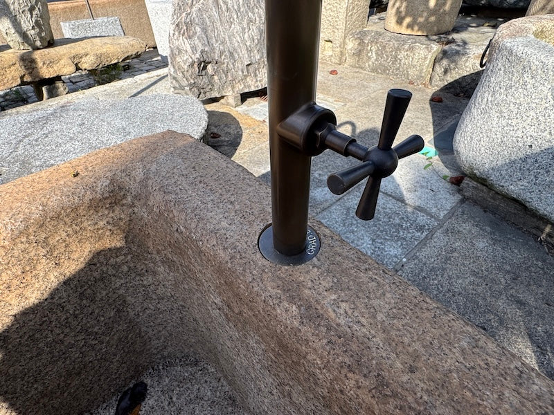 Steinbrunnen Österreich mit Wasserhahn und Handrad